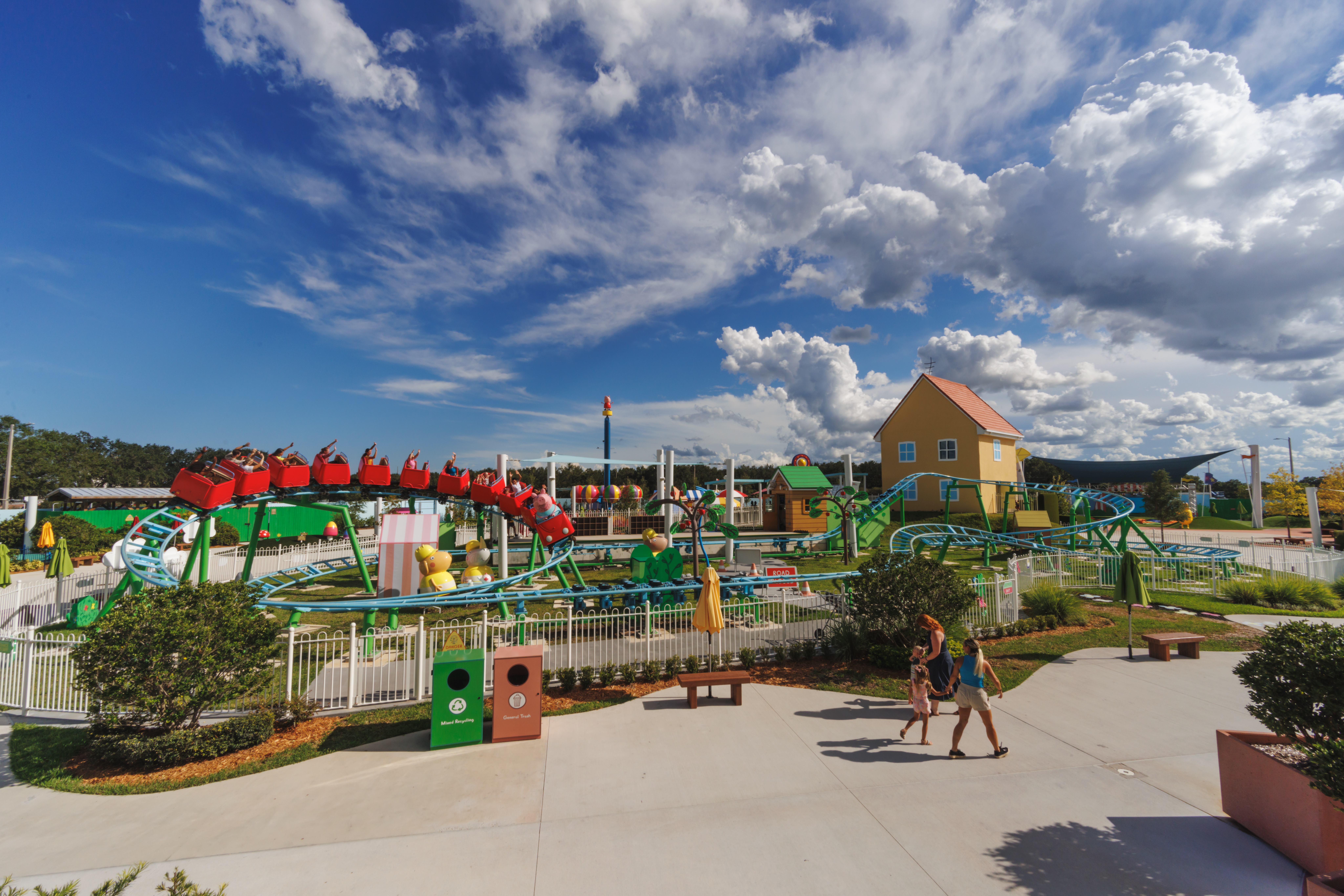 Image of the Daddy Pig Roller Coaster at PEPPA PIG Theme Park in Dallas. The colorful roller coaster features a playful design inspired by the beloved children's character Daddy Pig from the Peppa Pig franchise.